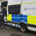 Devon and Cornwall Police van with officers at the rear during a warrant operation