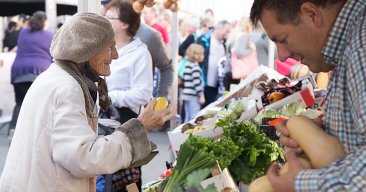 Customer buying vegetables at a market stall