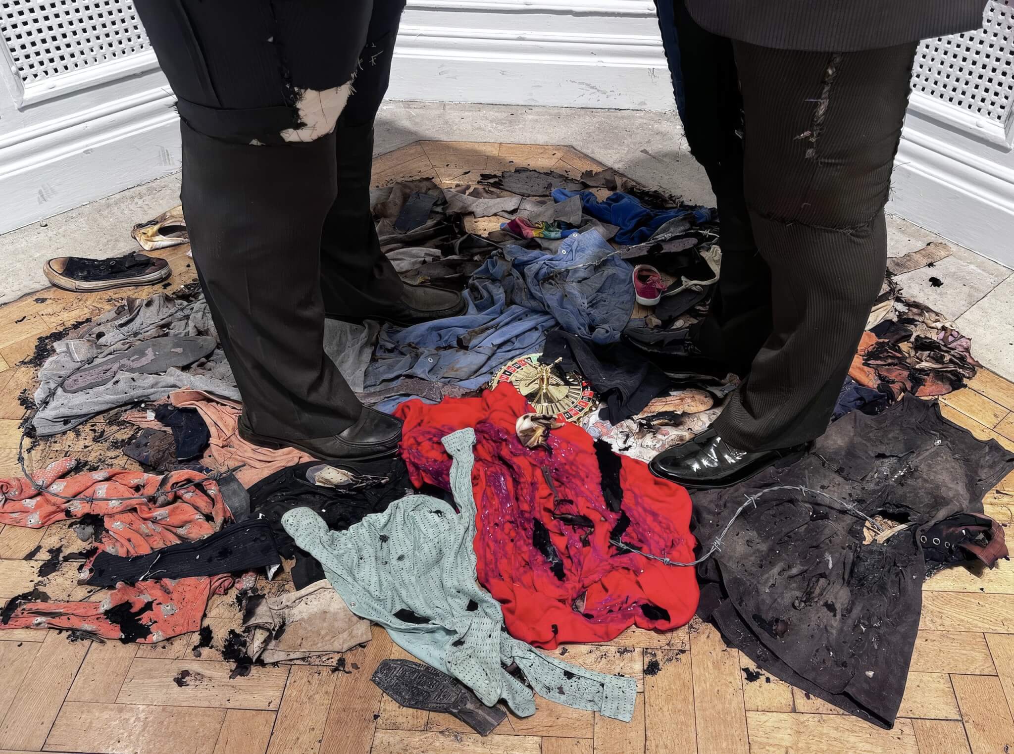 Charred clothing and a roulette wheel at the base of Pin It On Them