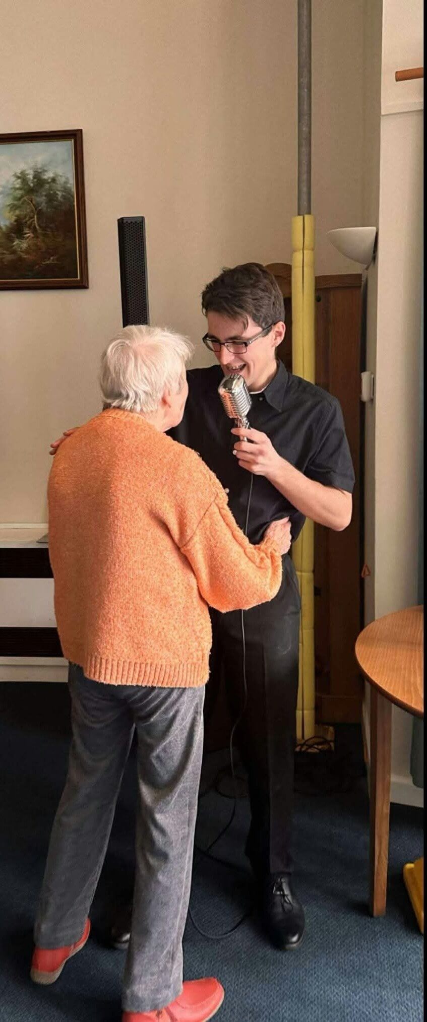 Jacob Reed singing as a care home resident dances with him