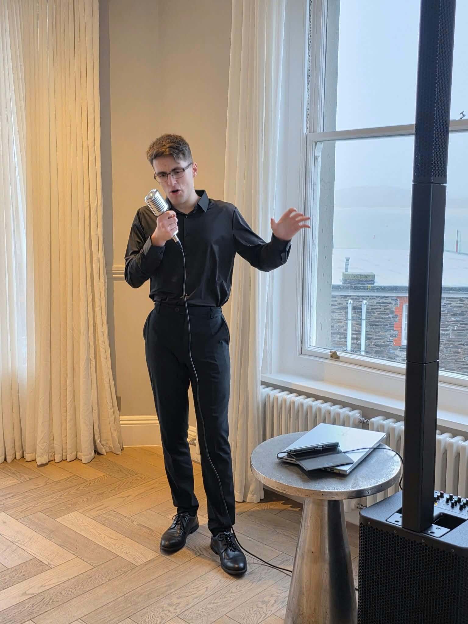 Jacob Reed performing beside a window