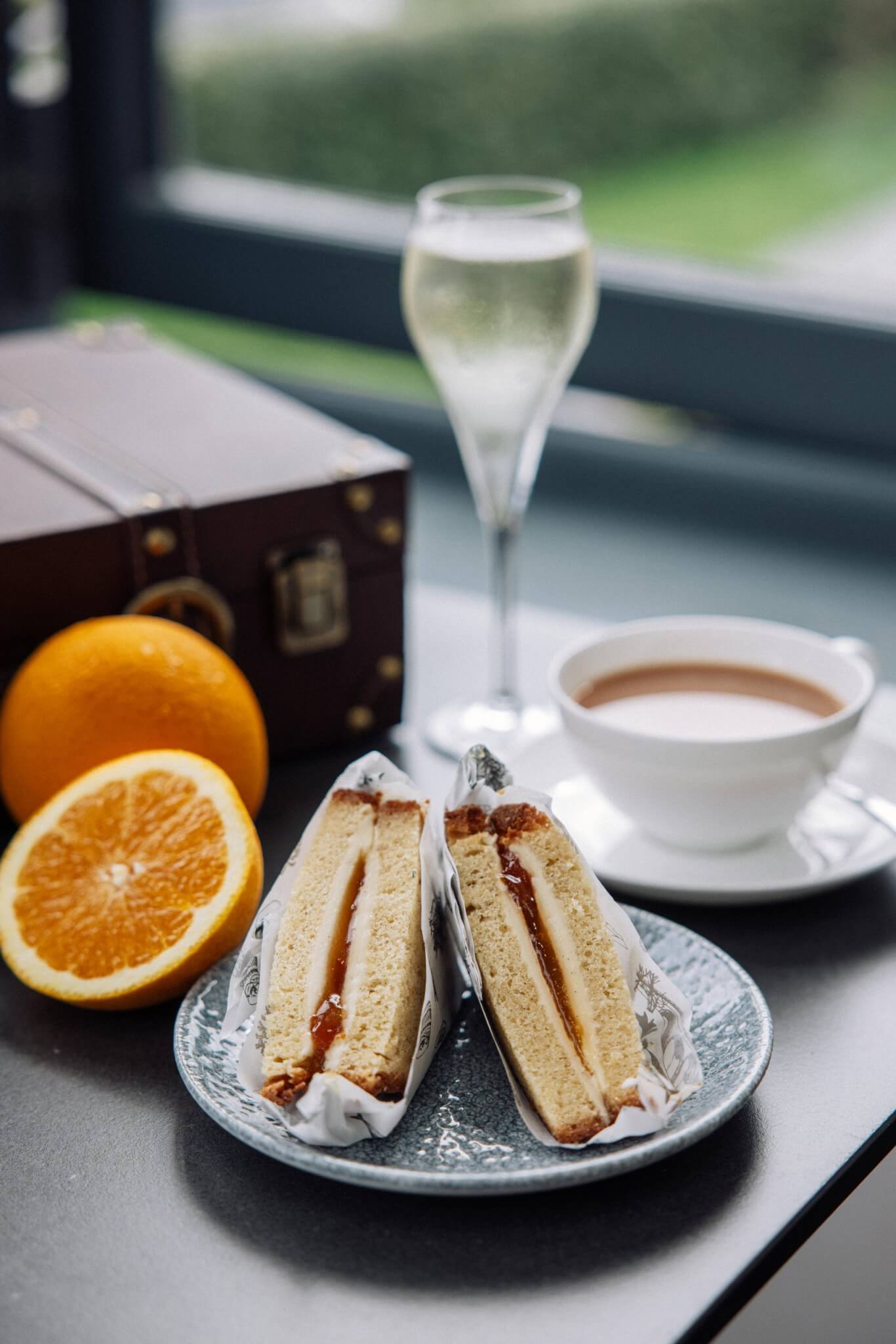 Marmalade sandwiches with a halved orange and a cup of tea