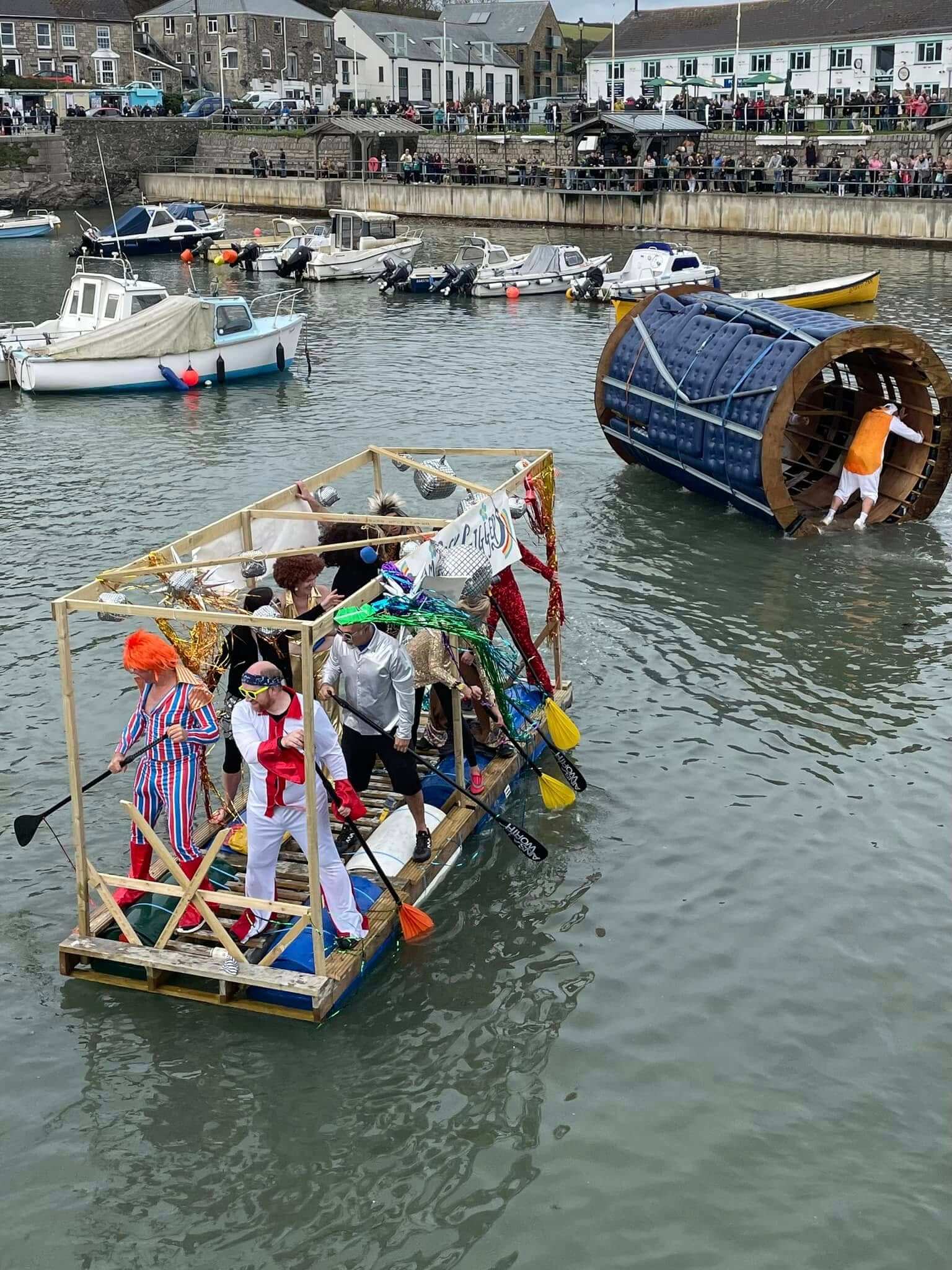 Fancy-dress crews racing home-built rafts across Porthleven Harbour