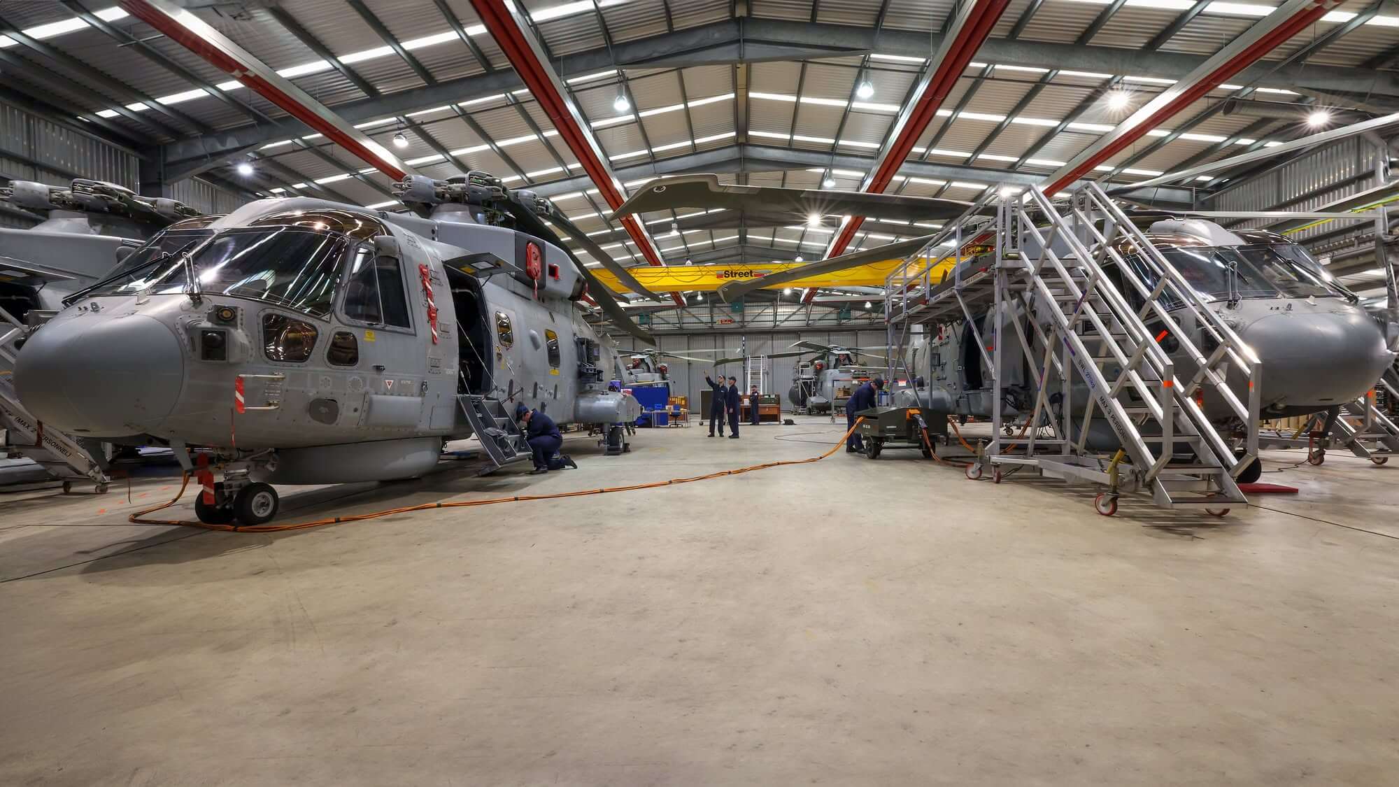 Royal Navy Merlin helicopters lined up inside a Culdrose hangar