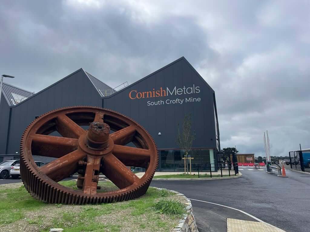 Cornish Metals South Crofty Mine building with a giant rusted gear wheel outside