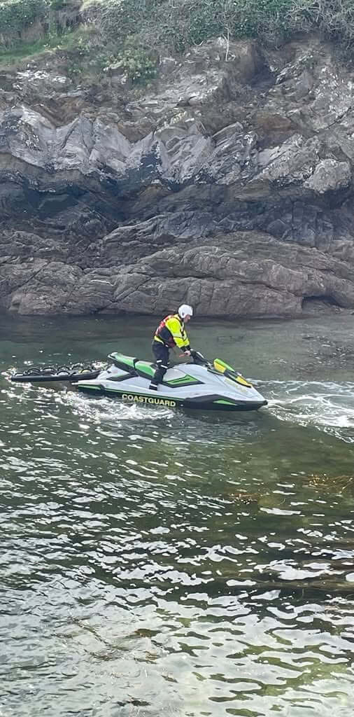 Coastguard personal watercraft below rocks