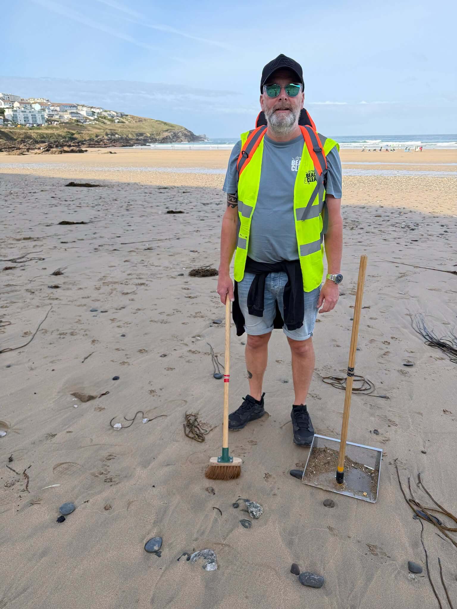 Fistral Beach Clean volunteer with a brush and long-handled sieve on Fistral Beach