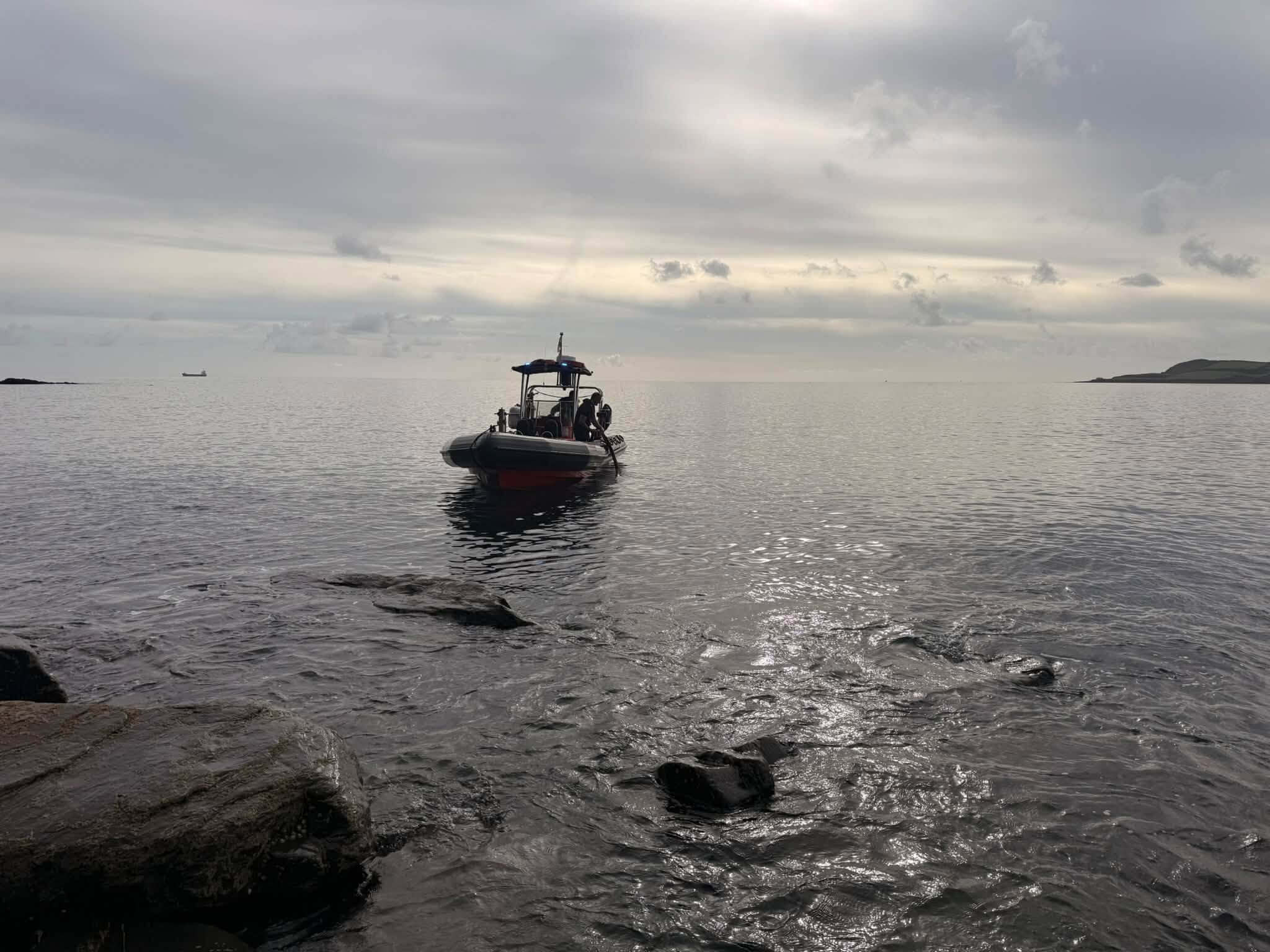 Falmouth fire boat on the water off the rocks near Mawnan