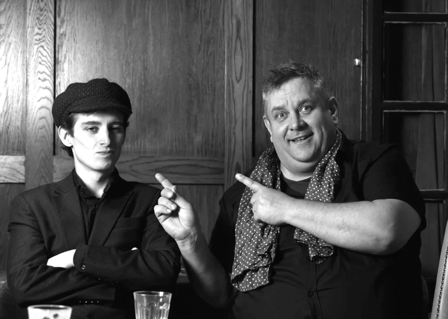 Ben Waters and Tom Waters, father and son musicians, pointing and smiling
