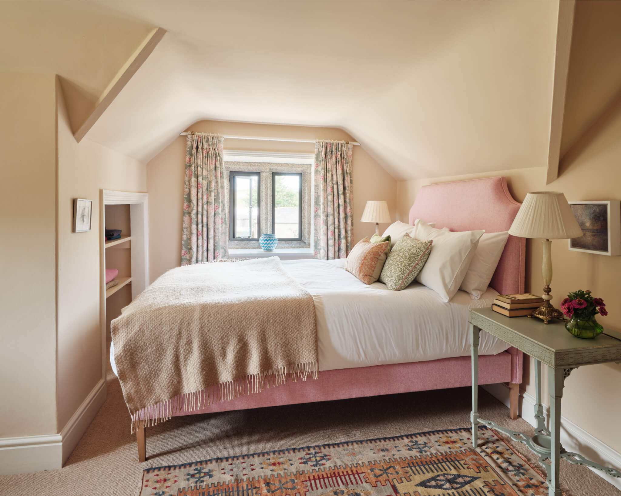 A colourful bedroom at Hamatethy with a pink upholstered bed
