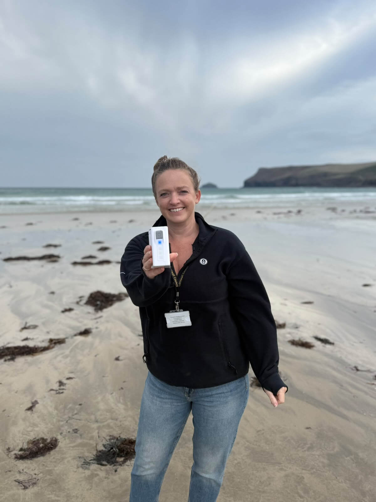 Cllr Rosie Moore holding a water testing kit on the beach