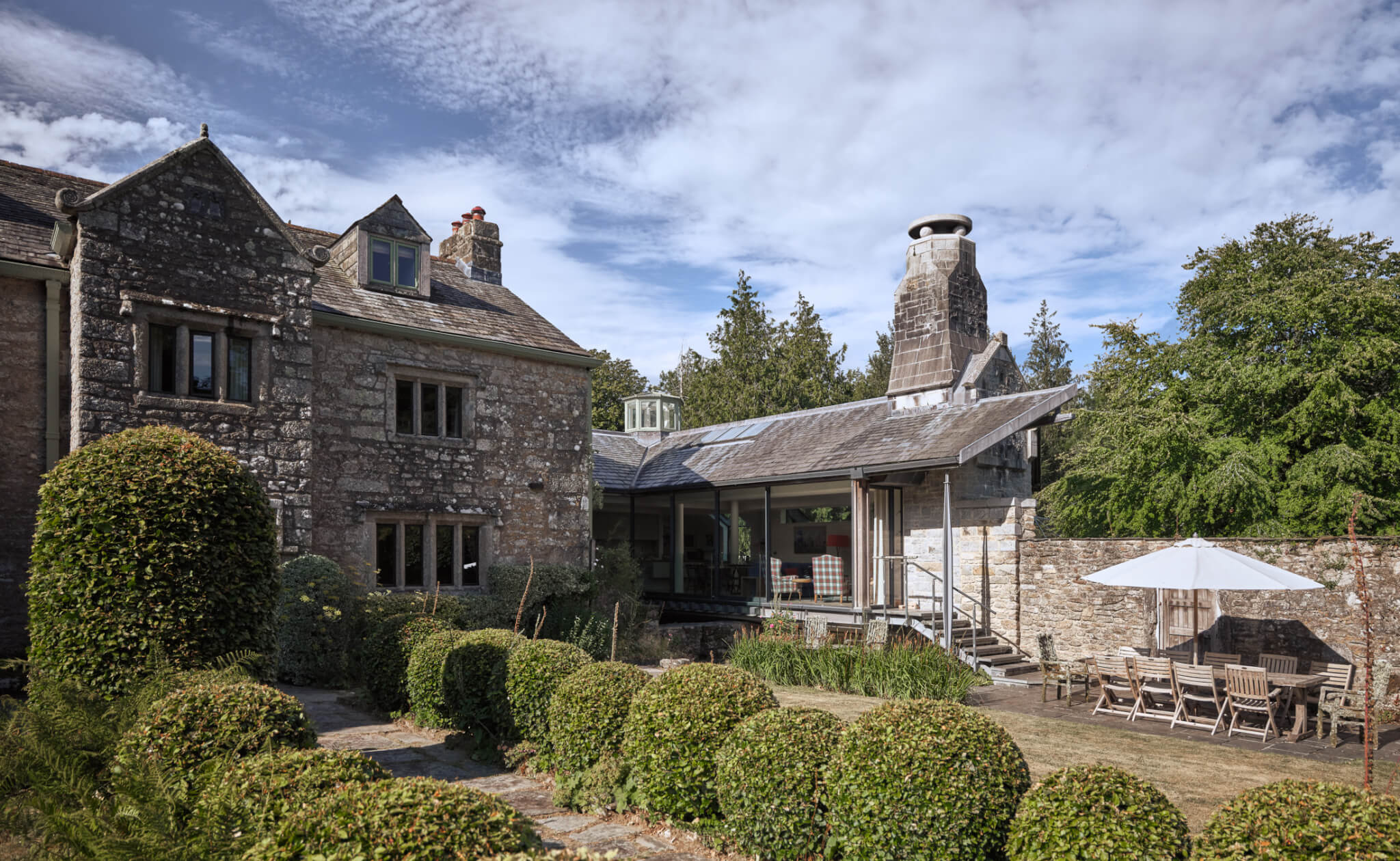 Hamatethy's stone farmhouse seen across the lawn and clipped hedges