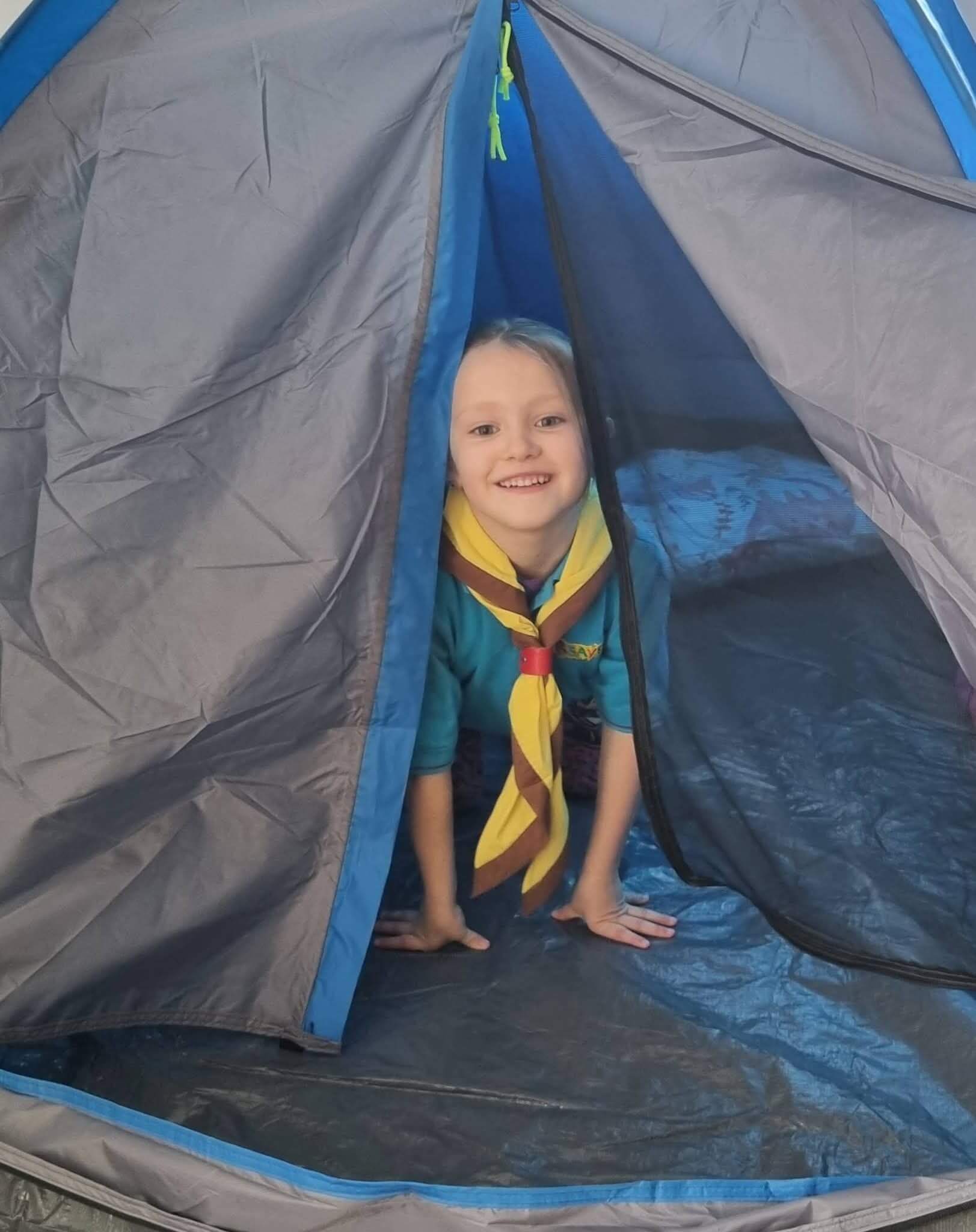 Grace grinning through the door of a tent