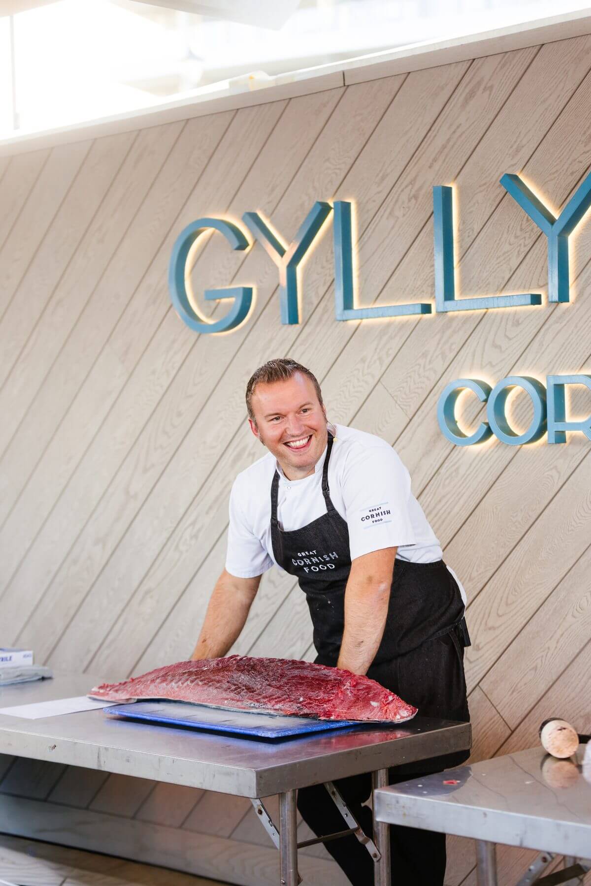 A chef smiling behind a prepared tuna loin at Gylly Beach