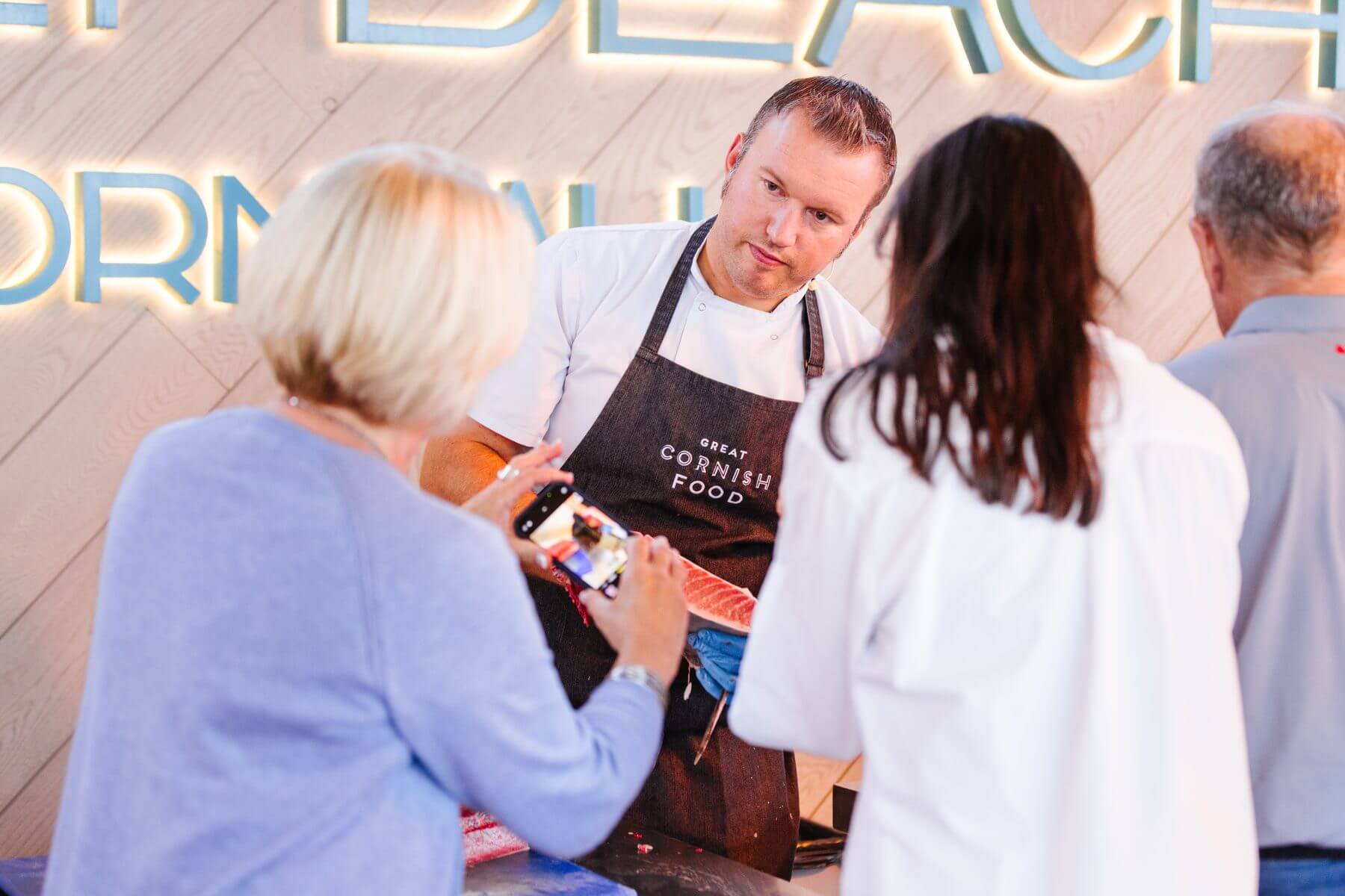 A chef showing prepared tuna to guests at Gylly Beach