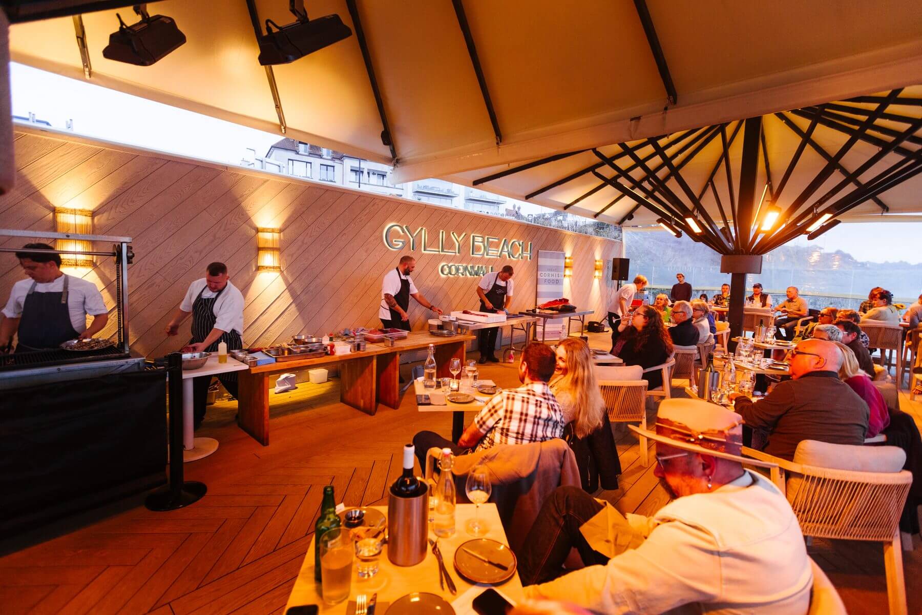 Guests dining as the sun sets over the sea at Gylly Beach