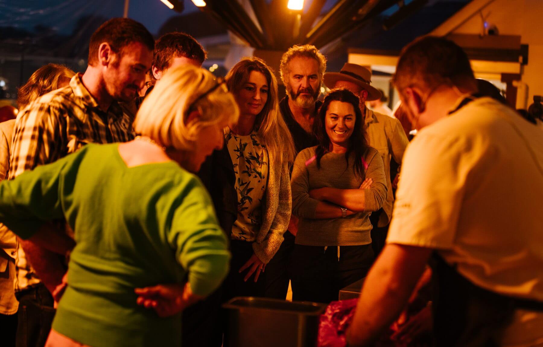 Guests gathered around the cutting table at Gylly Beach in the evening