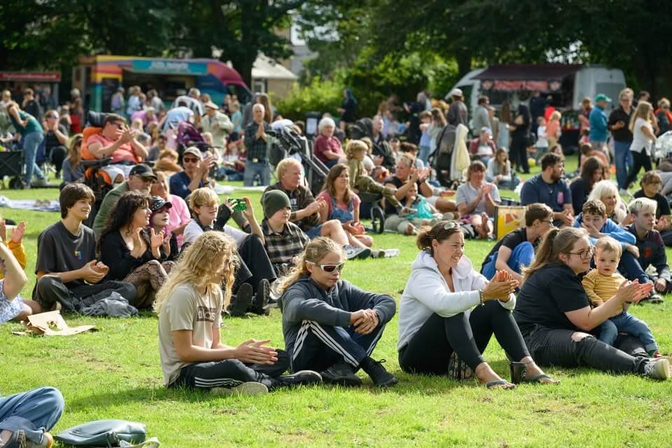 Families sitting on the grass at Camborne Green Fest