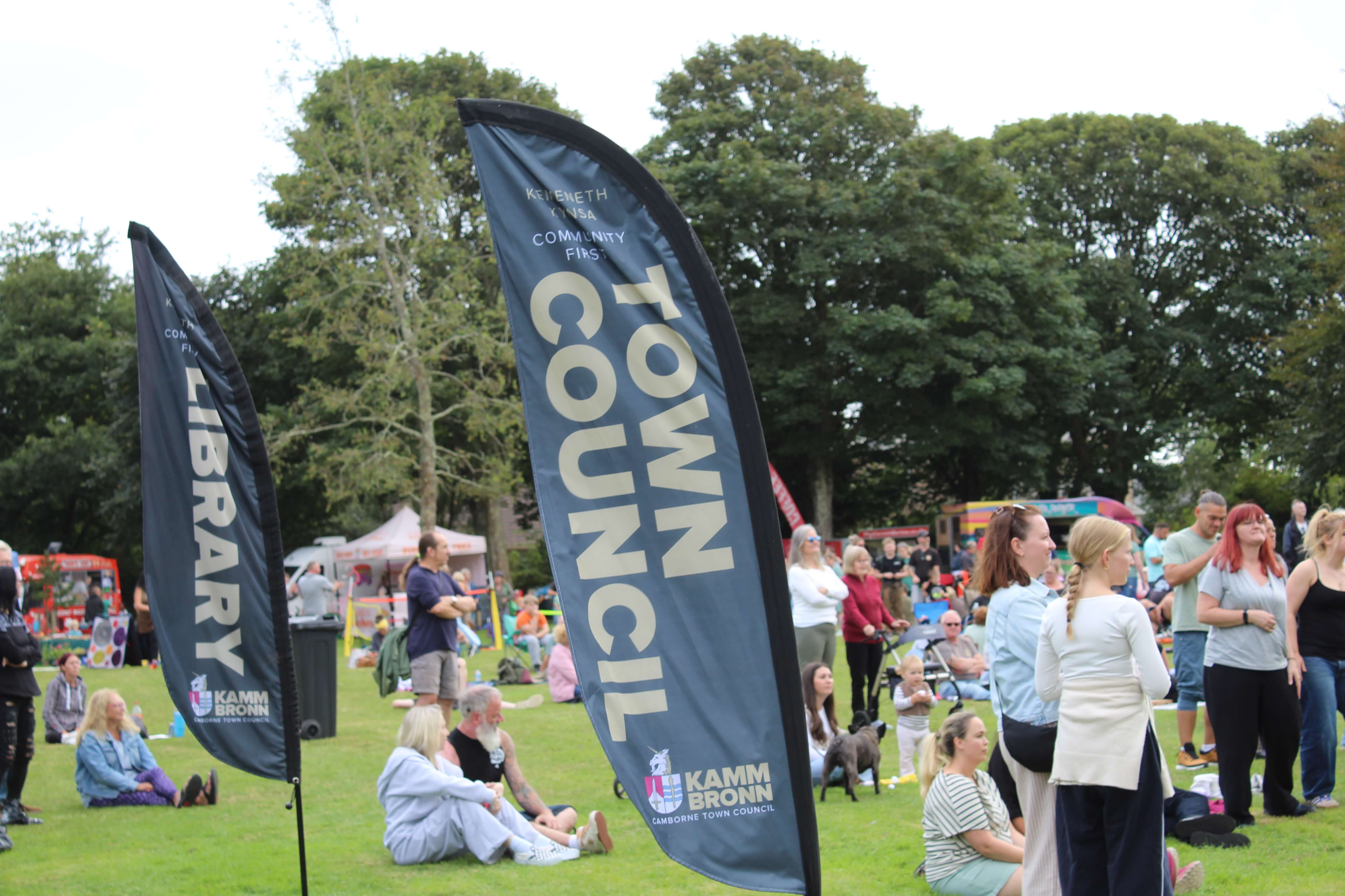 Camborne Town Council and library flags above the crowd at Green Fest