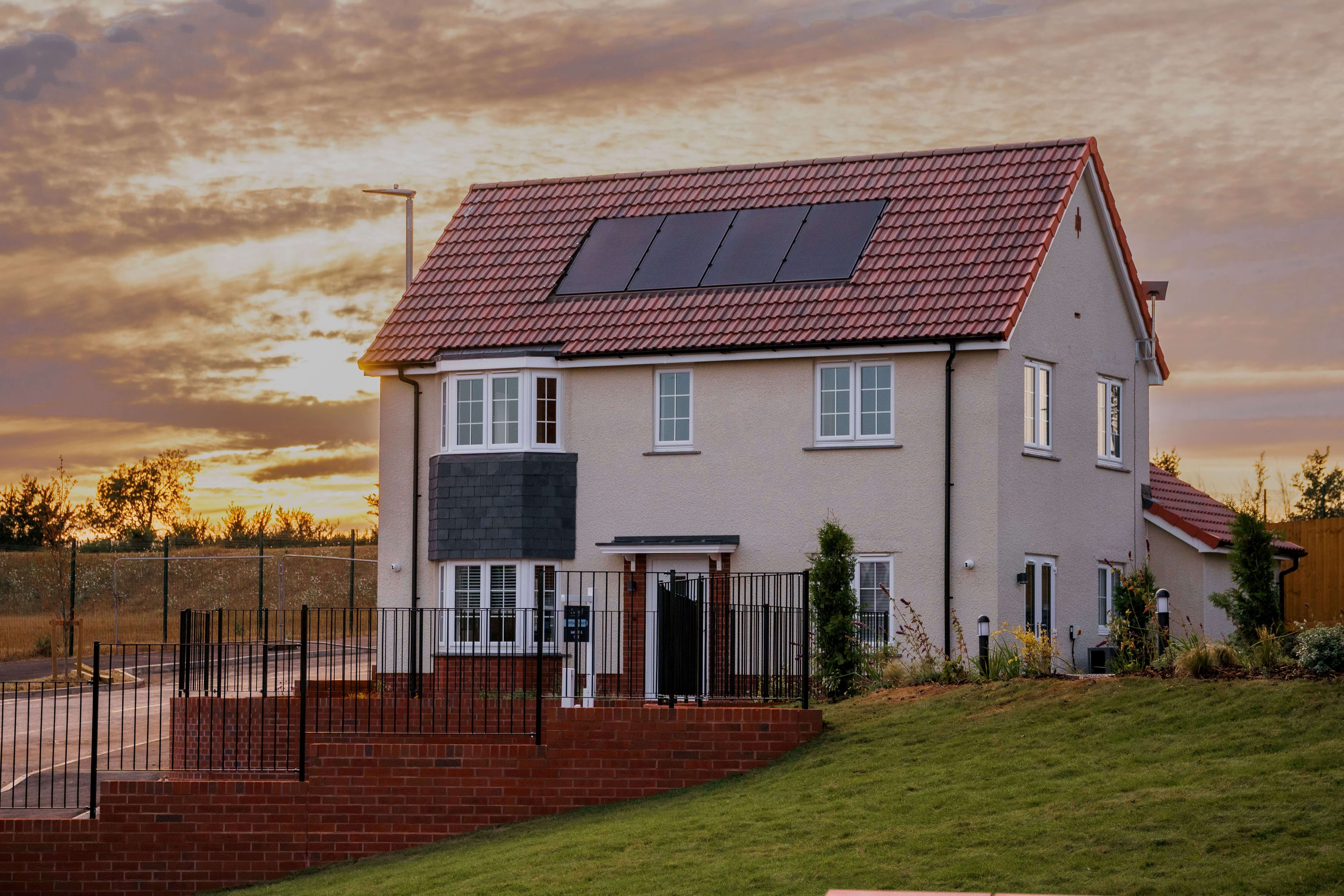 New-build show home with solar panels at sunset