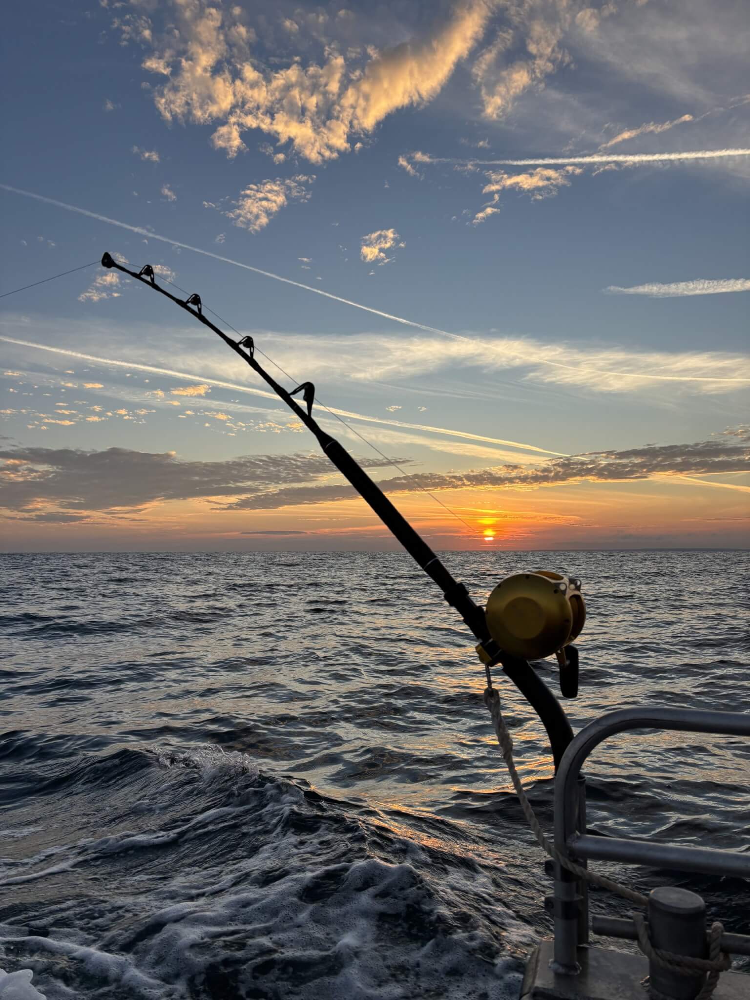 Tuna fishing rod on a boat at sunset over the sea