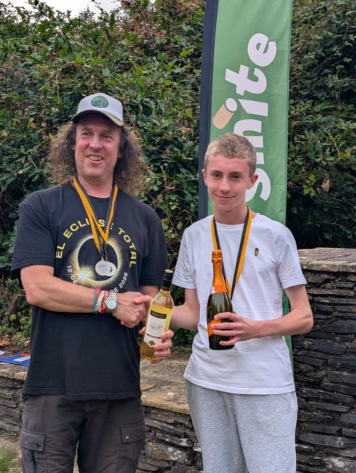 Singles champion and runner-up shaking hands with medals and prizes at the World Smite Championships