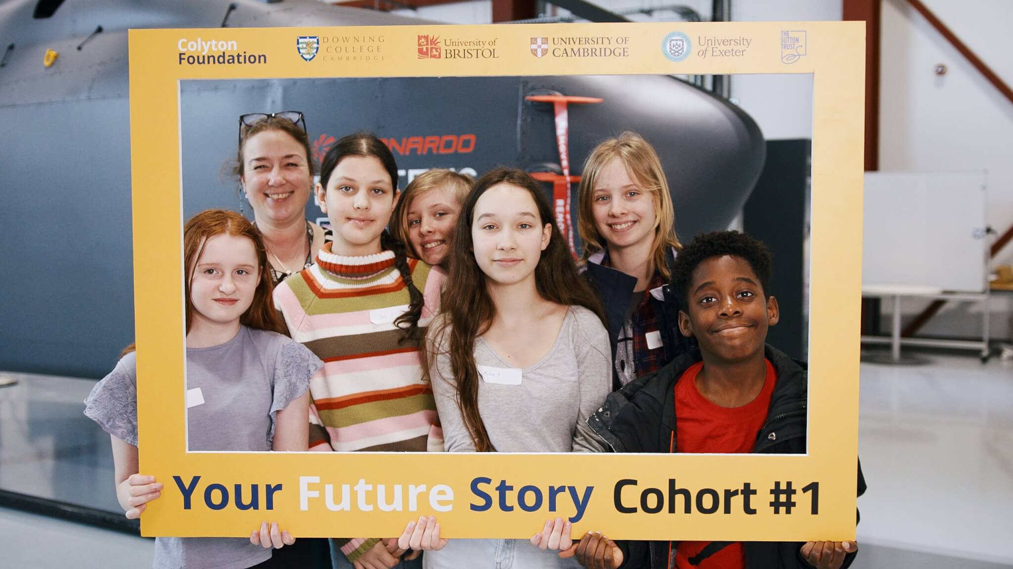 Students and a teacher posing in a Your Future Story Cohort #1 photo frame
