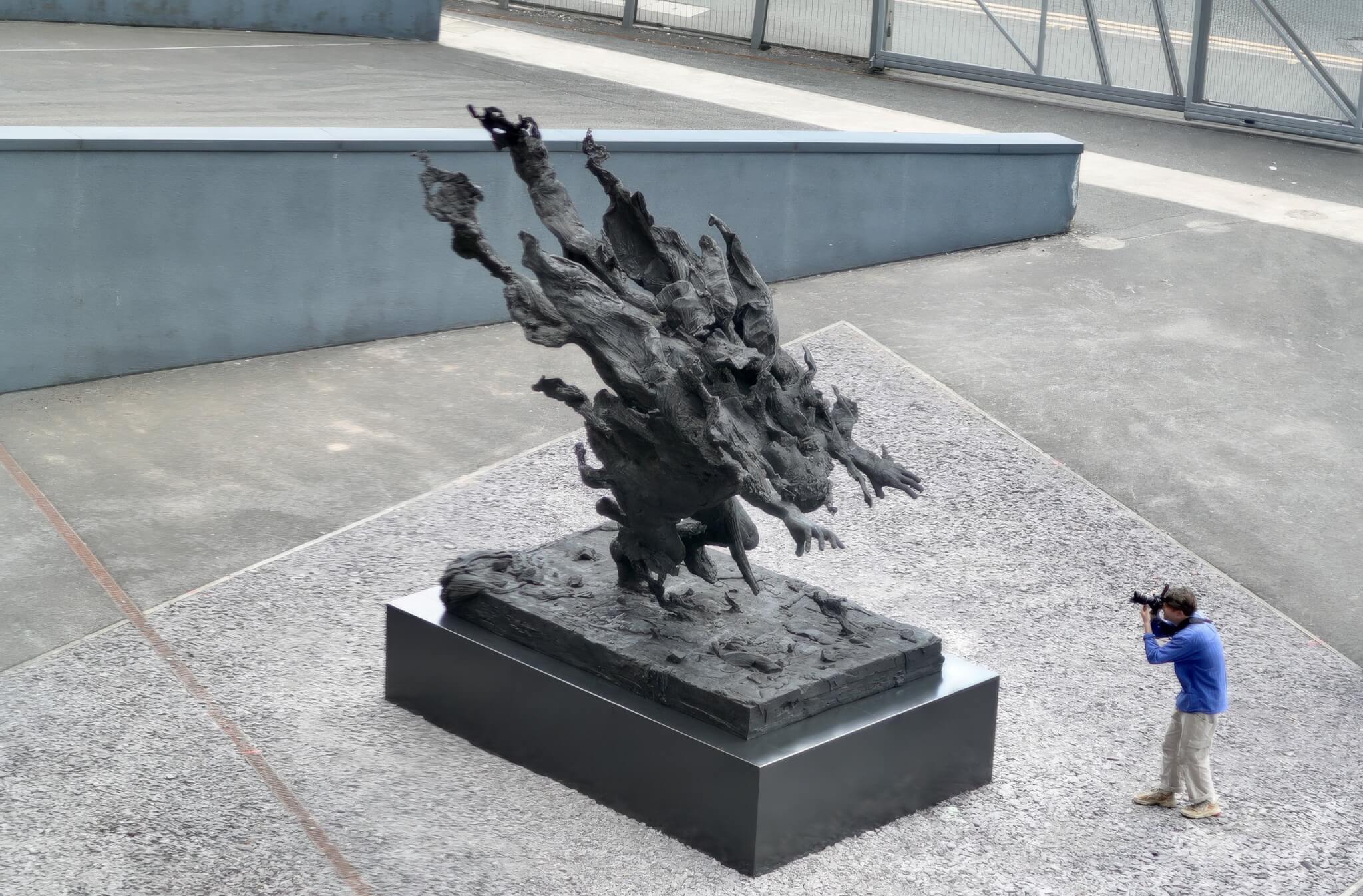 Tim Shaw's Man on Fire bronze with a photographer beside it for scale