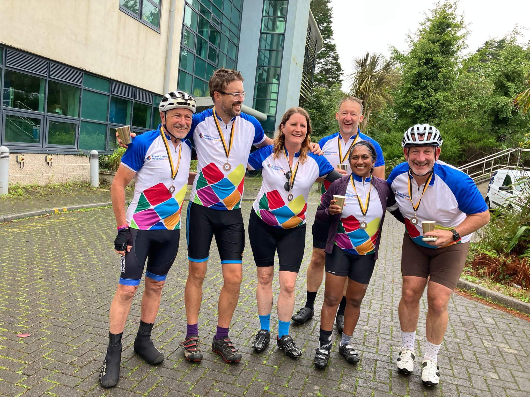 Tour de Kernow riders with medals outside Royal Cornwall Hospital