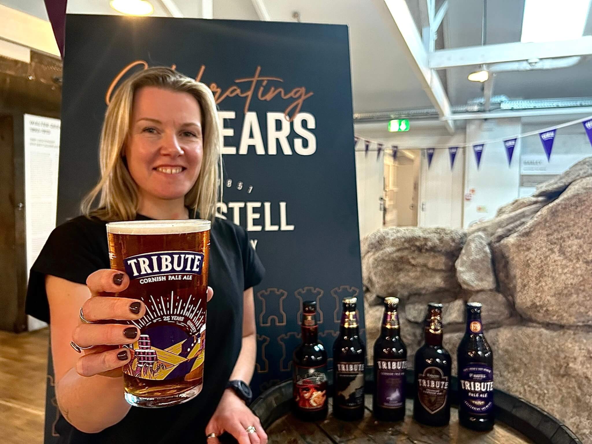 Jo Geeves holding a pint in the new commemorative Tribute glass at St Austell Brewery
