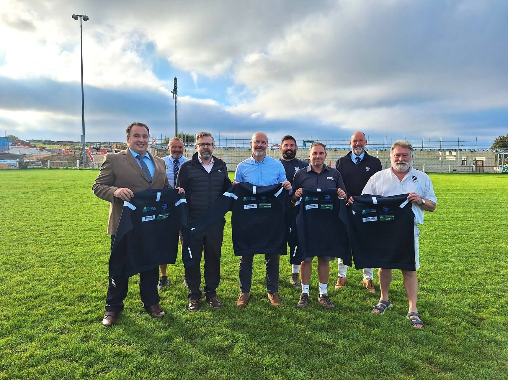 St Ives RFC representatives and sponsors holding up navy off-field jumpers at the ground