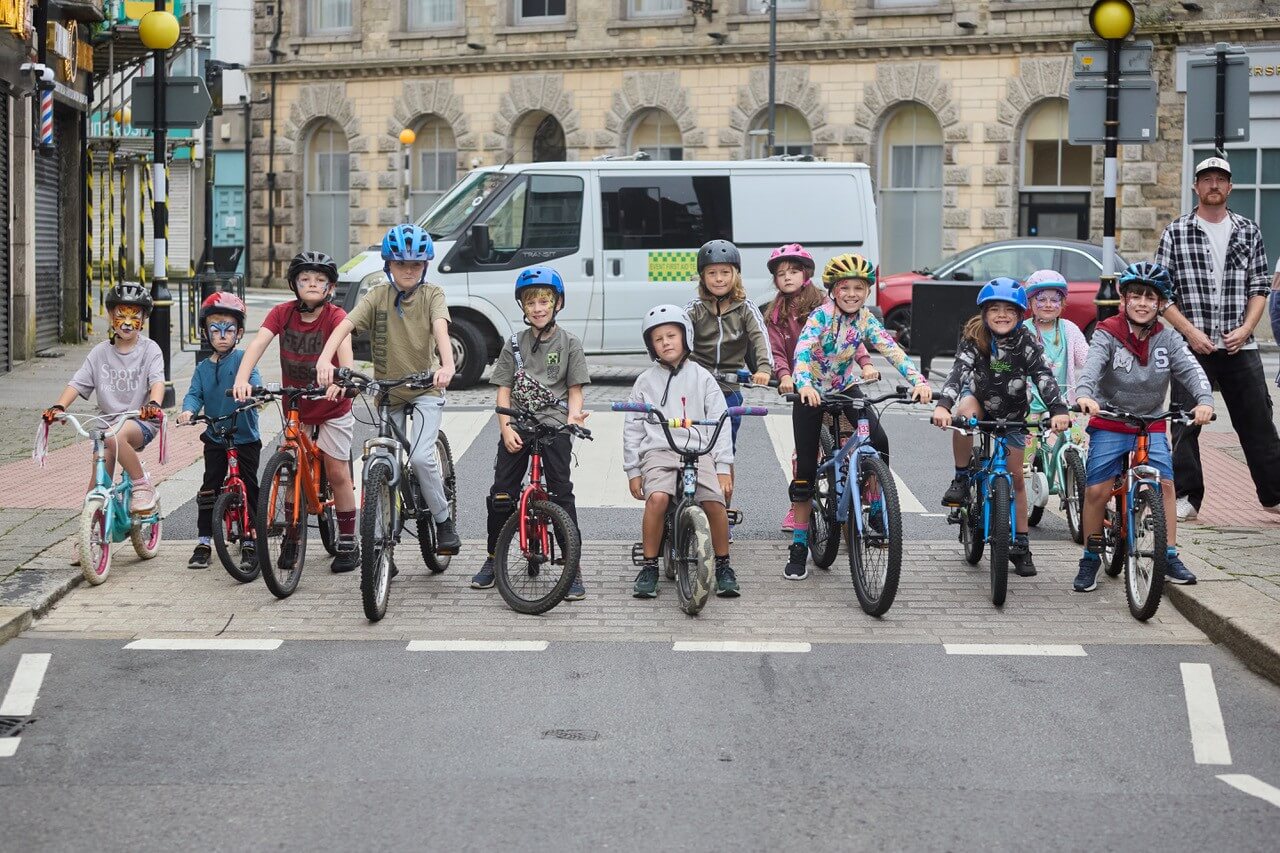 Children lined up on bikes and trikes on Trelowarren Street in Camborne for Tykes on Trikes