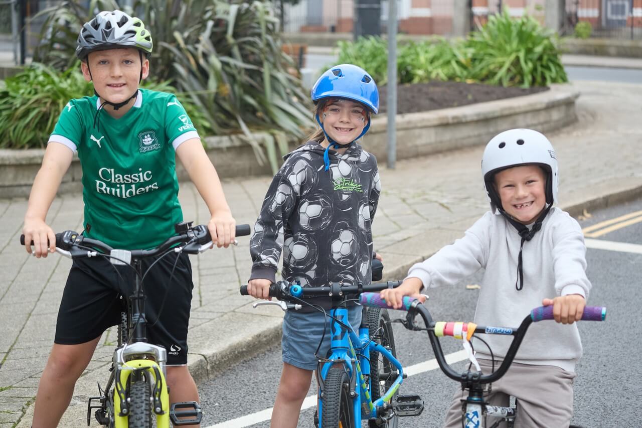 Three young cyclists with helmets on ahead of the Tykes on Trikes race in Camborne