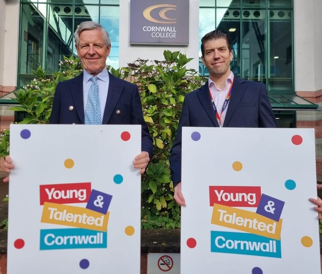 Two men holding Young & Talented Cornwall signs outside Cornwall College
