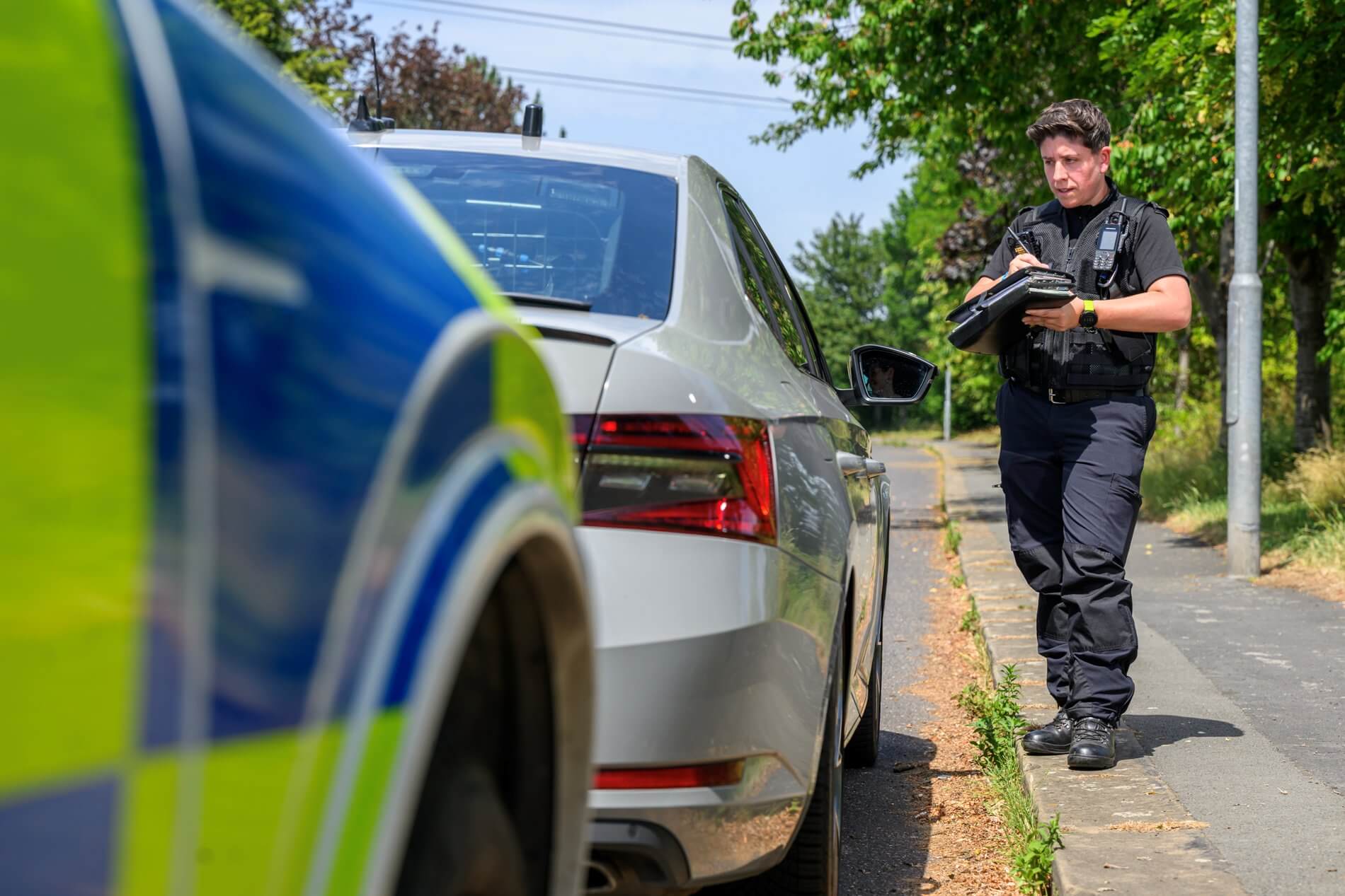 Police officer checking a vehicle's details at the roadside