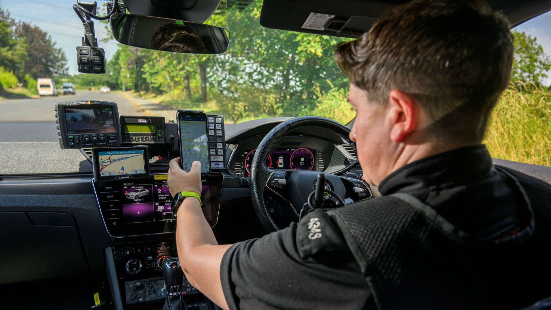 Police officer checking vehicle details on an in-car tablet