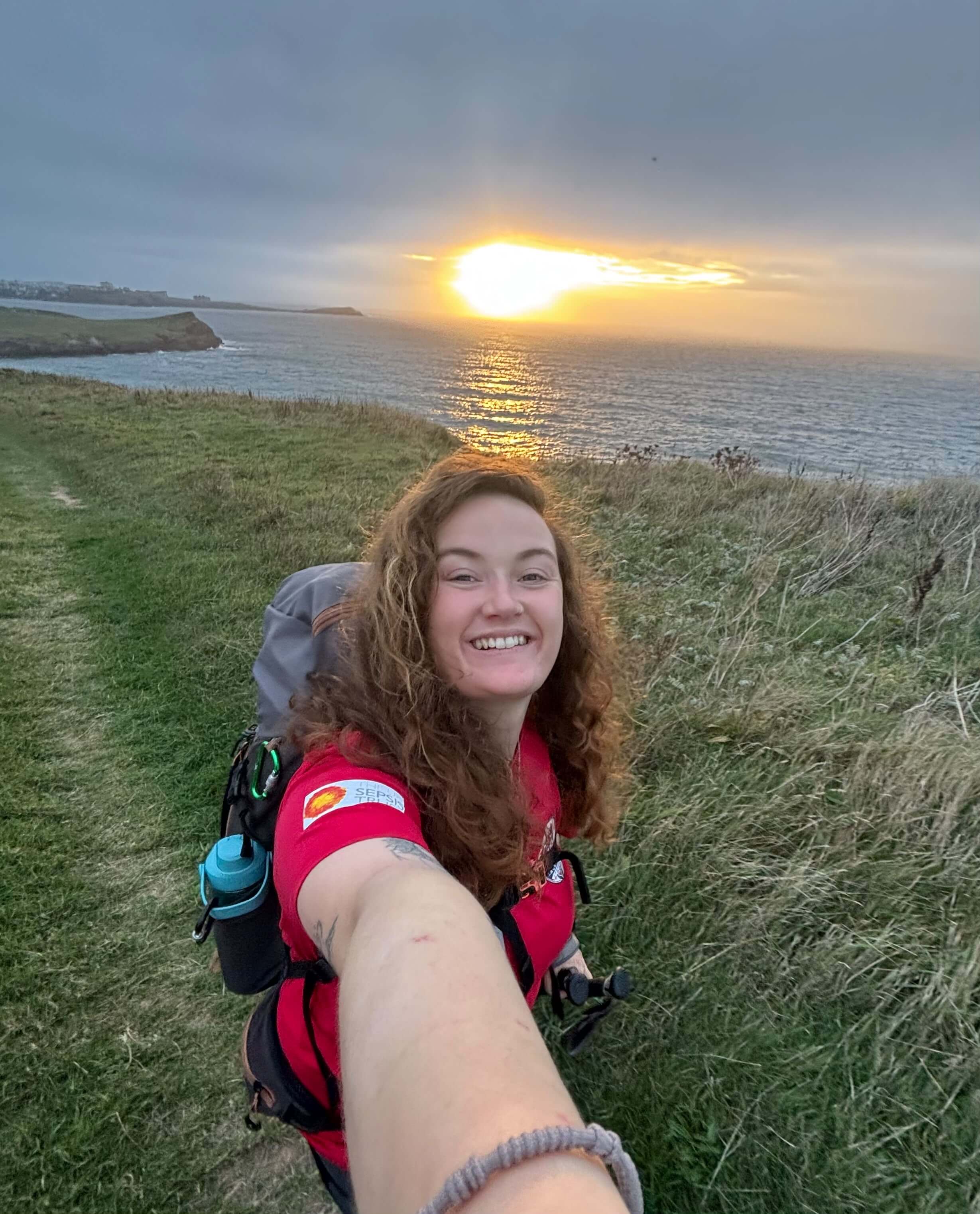 Skye Owen taking a selfie as the sun rises over the sea