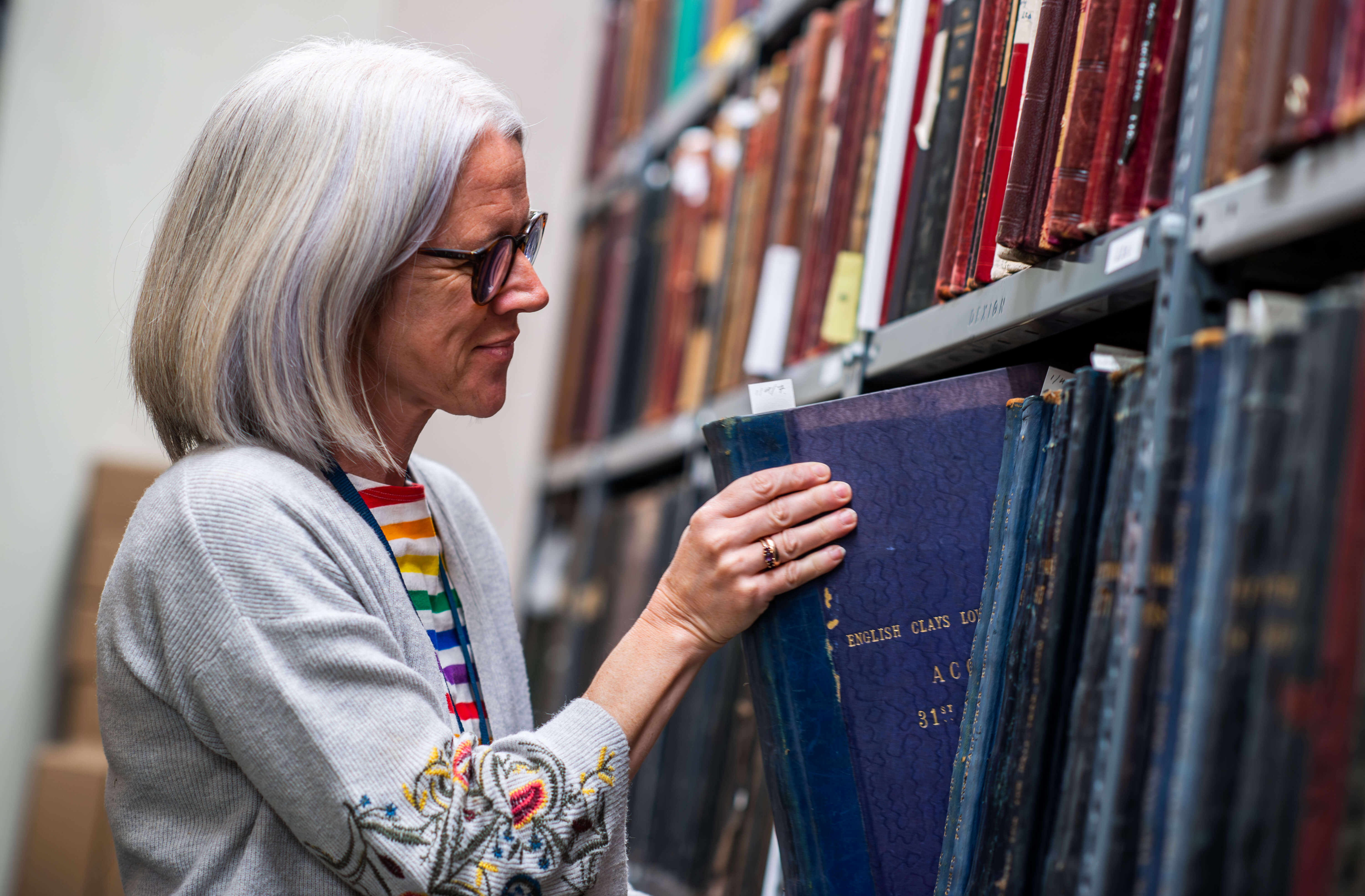 Wheal Martyn Collections Manager looking through archive volumes