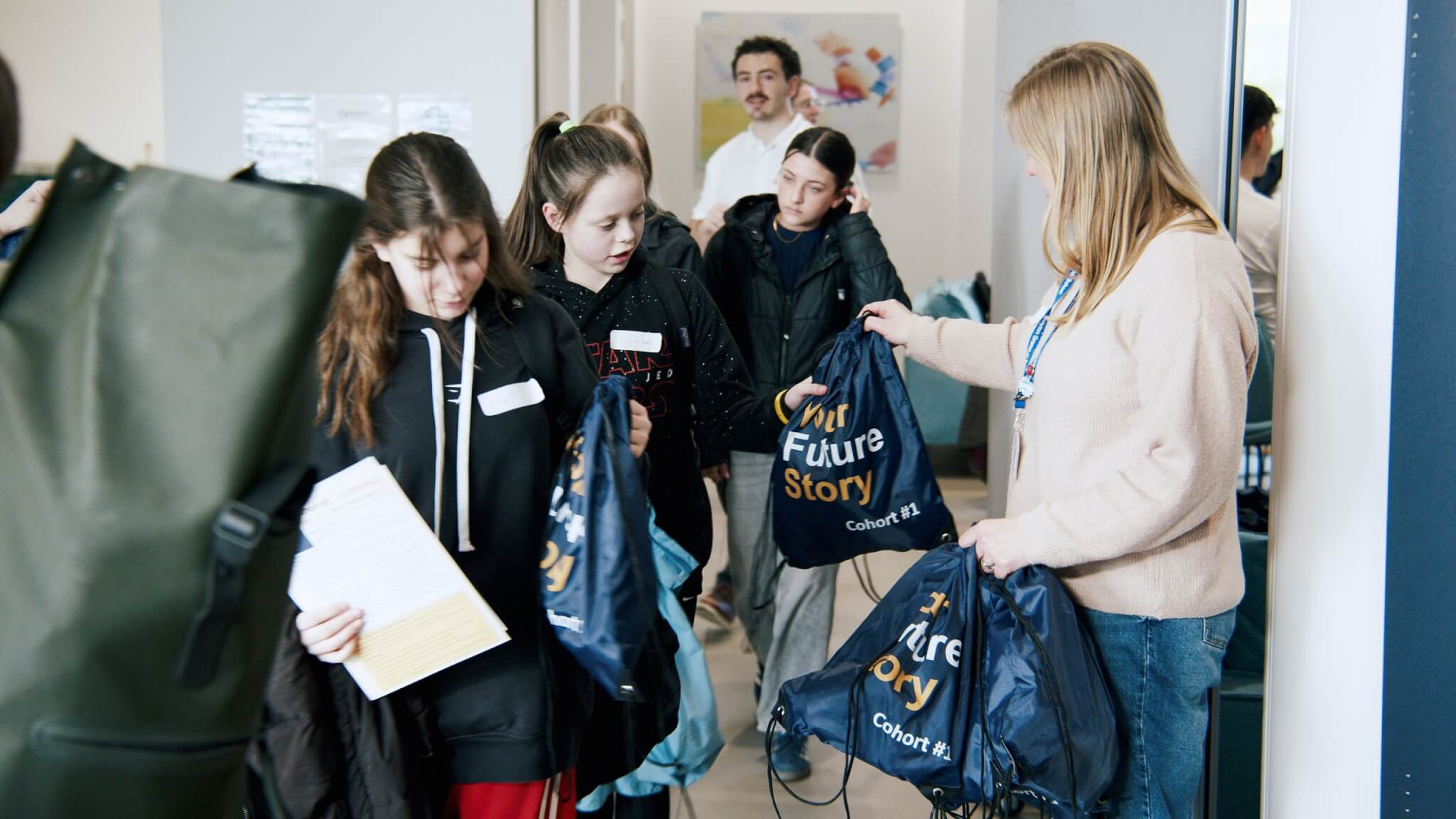 Students being handed Your Future Story Cohort #1 drawstring bags