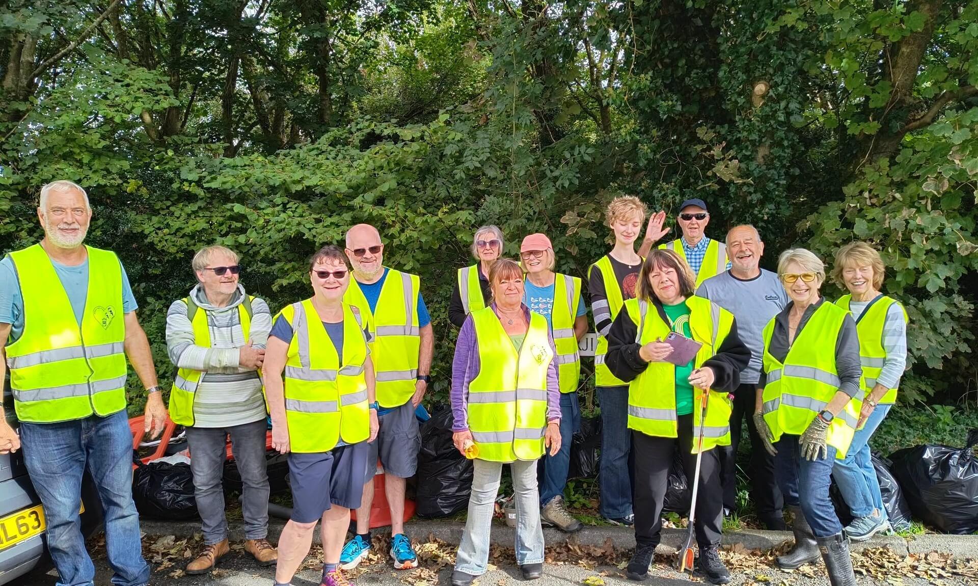 Bodmin Tidy it Team volunteers in hi-vis vests beside bags of collected rubbish