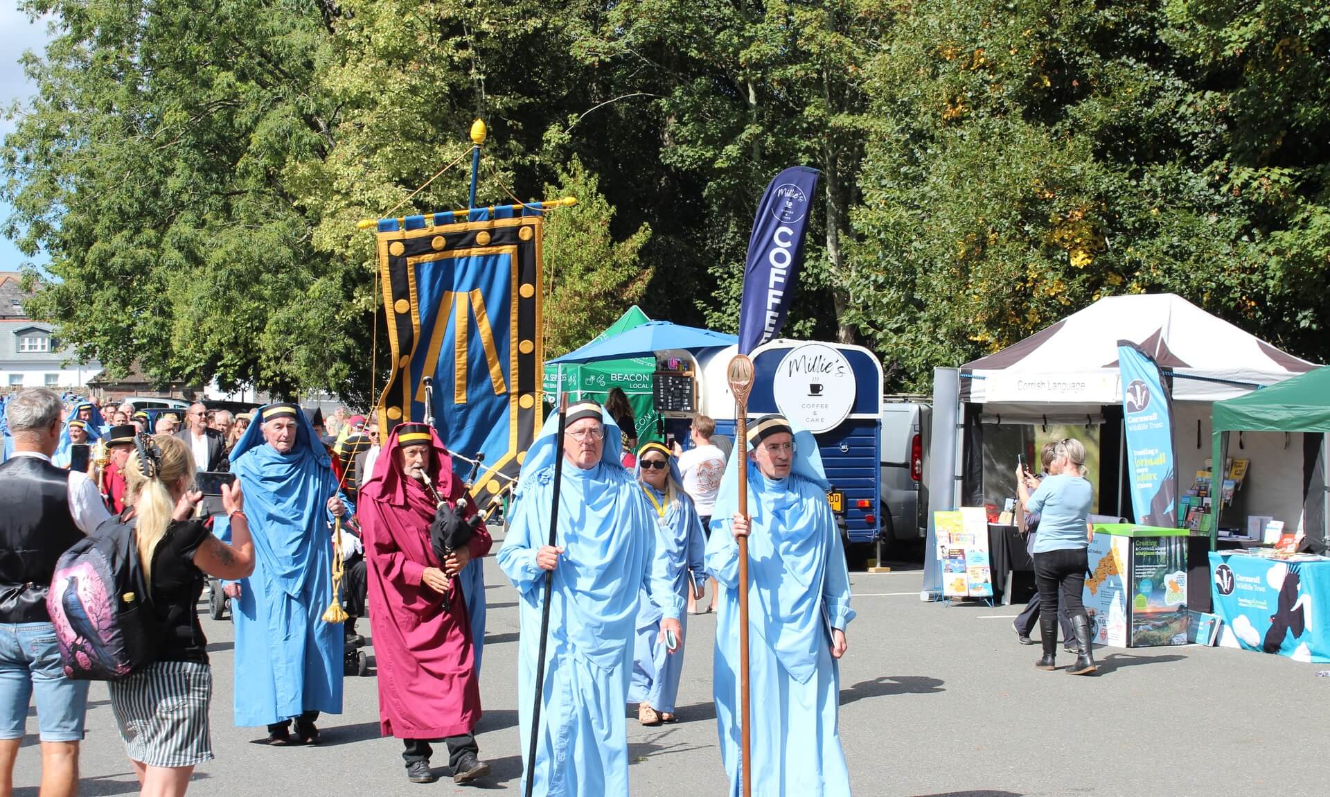 Blue-robed Cornish bards processing through Bodmin behind a banner and piper