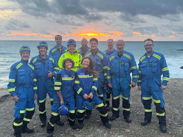 Bude Coastguard Rescue Team members stood together on a clifftop at sunset