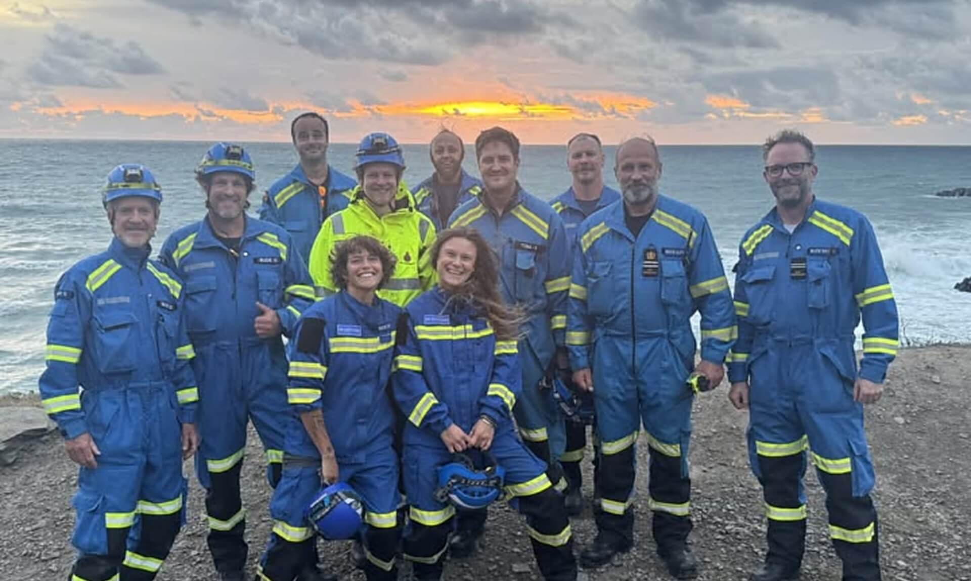 Bude Coastguard Rescue Team members stood together on a clifftop at sunset