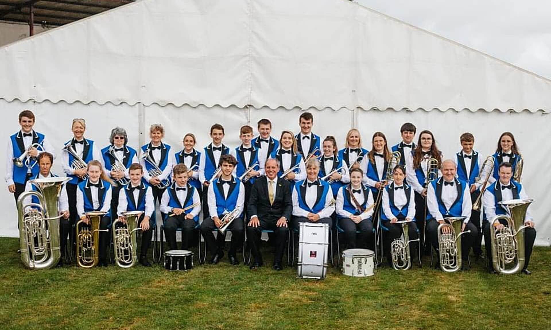 Camborne Brass band members posing together in their blue and black uniforms