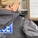Police officer posting a closure order notice on the window of Central Grill in Truro