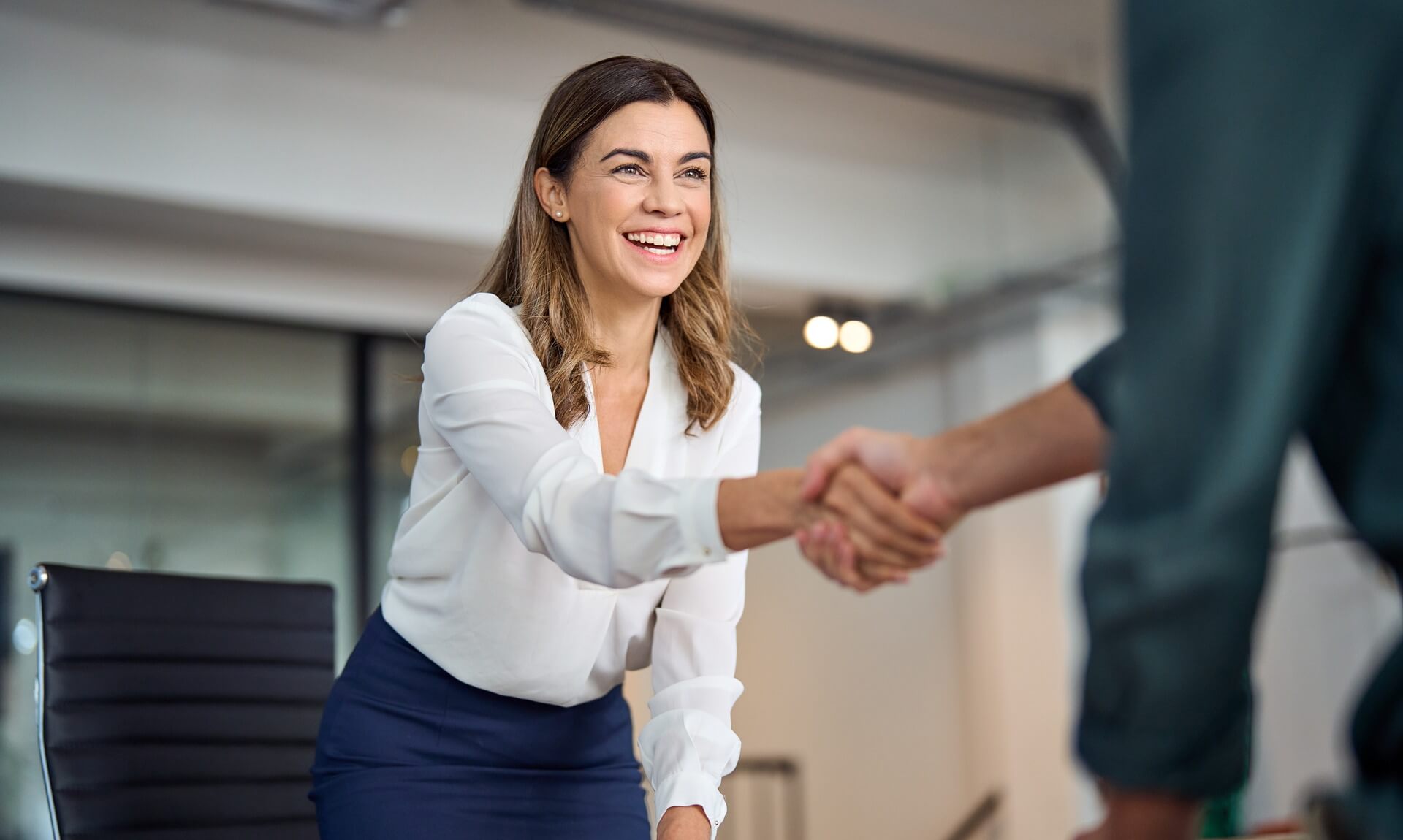 A recruiter shaking hands with a jobseeker in an office