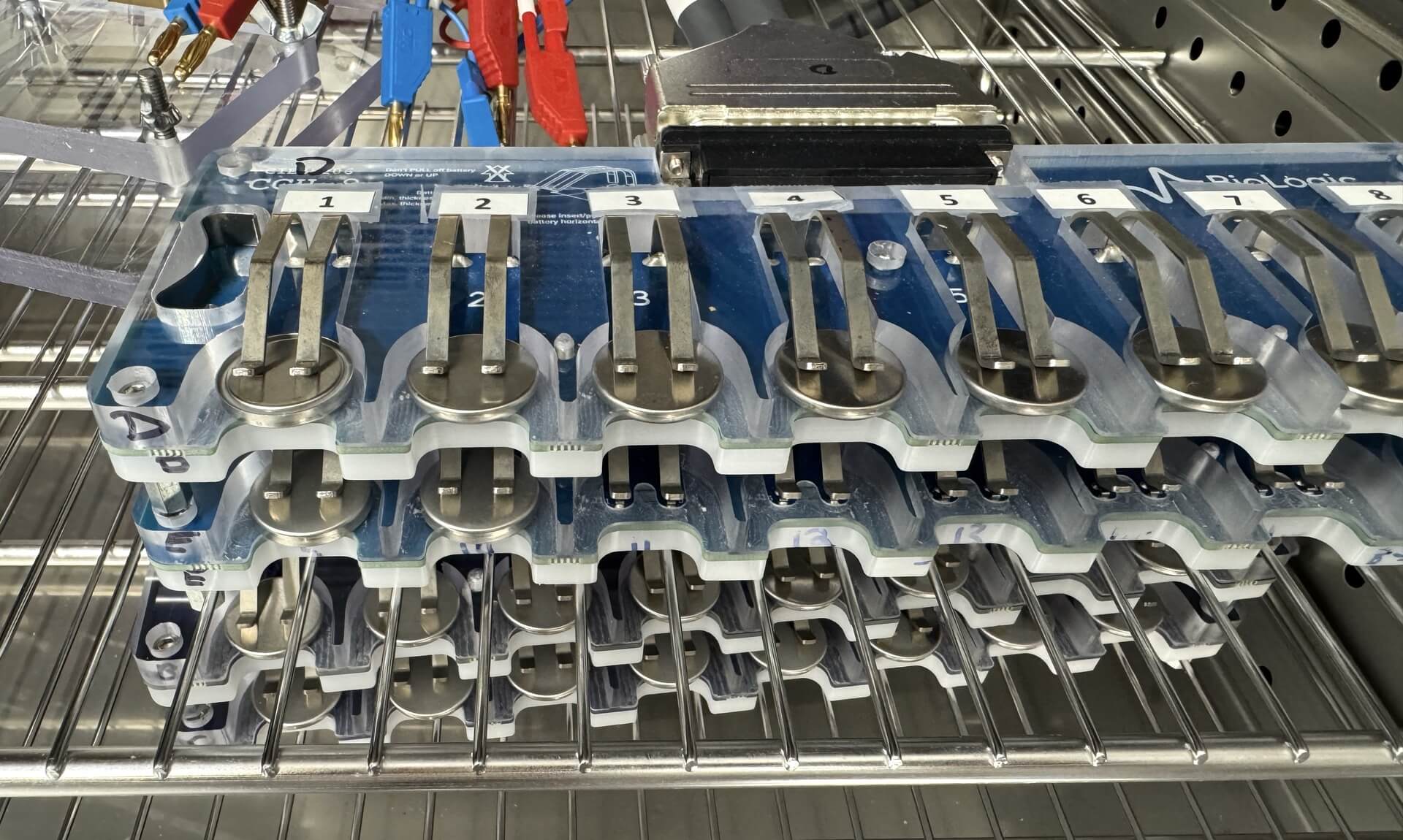 Coin cell batteries in a testing rack at CPI