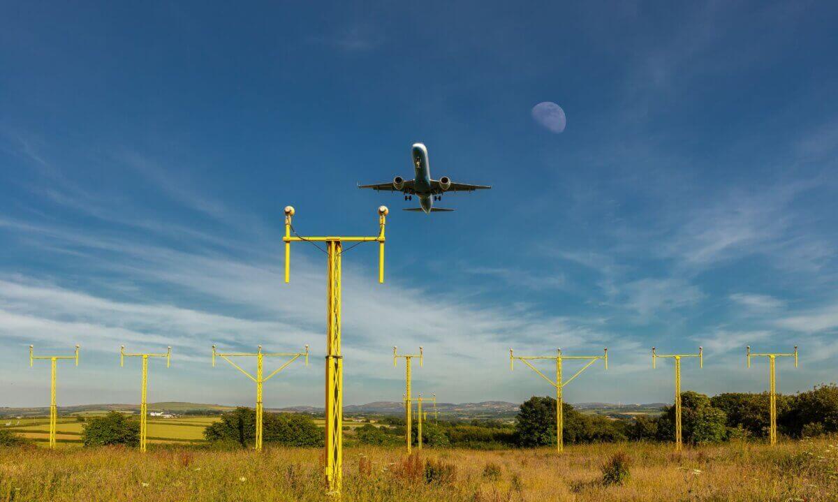 A plane comes in to land over the approach lights at Cornwall Airport Newquay