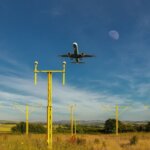 A plane comes in to land over the approach lights at Cornwall Airport Newquay