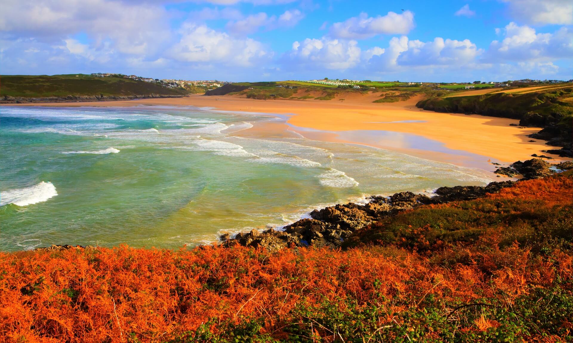 A Cornish beach and headland in autumn light, with orange bracken in the foreground